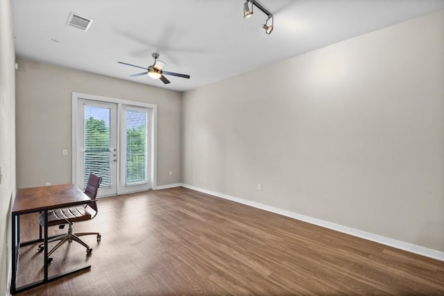 unfurnished office with ceiling fan, wood finished floors, visible vents, and baseboards