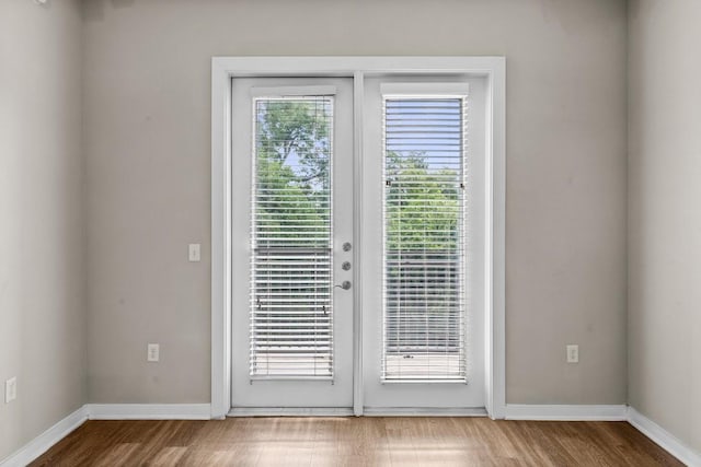 entryway with baseboards, wood finished floors, and french doors