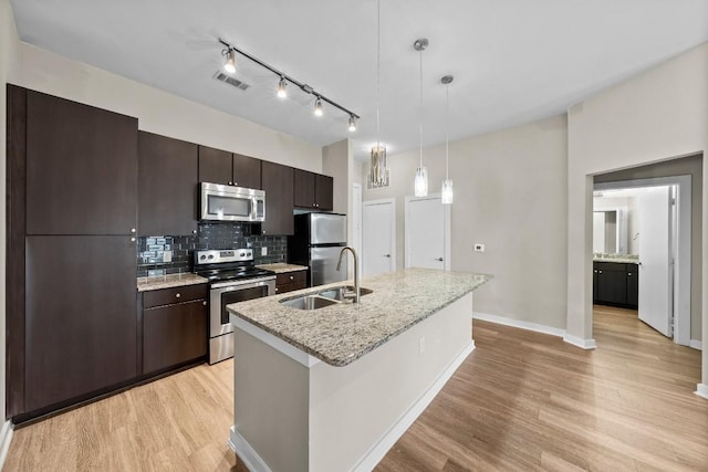 kitchen with dark brown cabinetry, visible vents, stainless steel appliances, light wood-style floors, and a sink