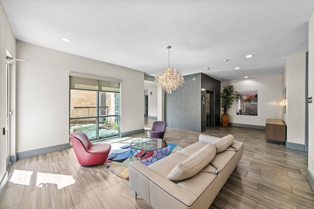 living room featuring recessed lighting, wood finish floors, a notable chandelier, and baseboards