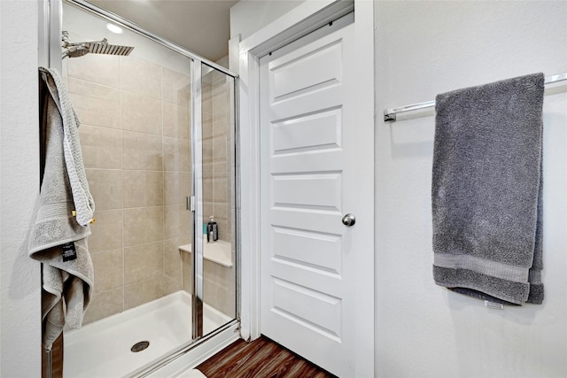 bathroom featuring hardwood / wood-style flooring and a shower with door