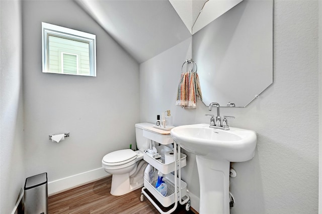 bathroom featuring wood-type flooring, vaulted ceiling, and toilet