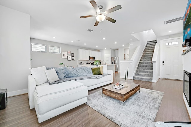 living room featuring light wood-type flooring and ceiling fan