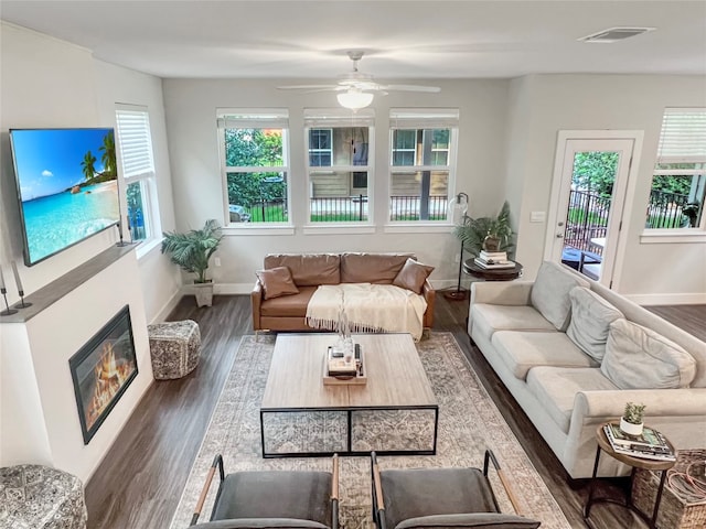 living room featuring ceiling fan and dark hardwood / wood-style flooring