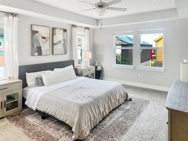 bedroom featuring light carpet, multiple windows, and ceiling fan