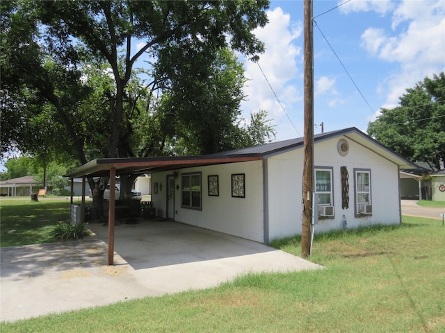 view of front of property featuring cooling unit, a carport, and a front lawn