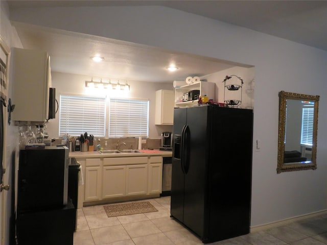 kitchen with white cabinetry, sink, light tile patterned flooring, and black fridge with ice dispenser