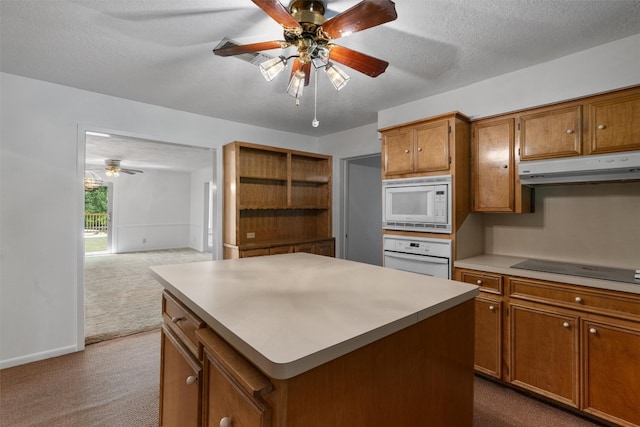 kitchen featuring a center island, carpet flooring, ceiling fan, and white appliances