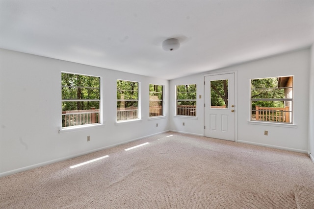 carpeted empty room featuring lofted ceiling