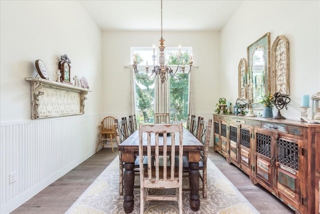 dining space featuring hardwood / wood-style floors and an inviting chandelier