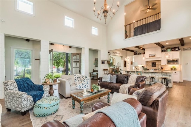 living room featuring light wood-type flooring, high vaulted ceiling, and a healthy amount of sunlight