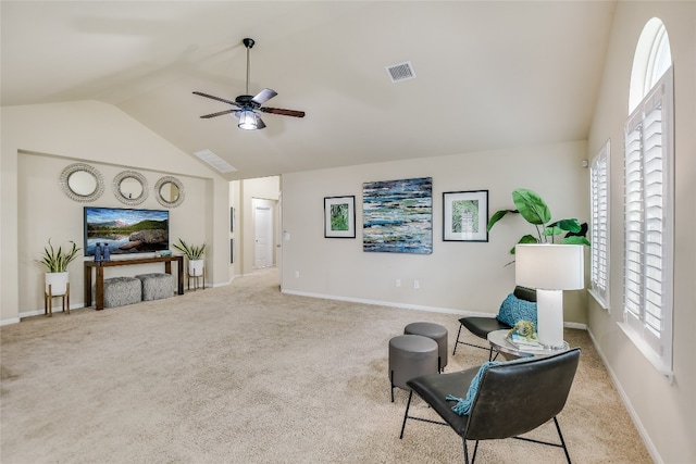 sitting room with ceiling fan, lofted ceiling, and light colored carpet