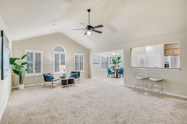 sitting room with lofted ceiling, light colored carpet, and ceiling fan