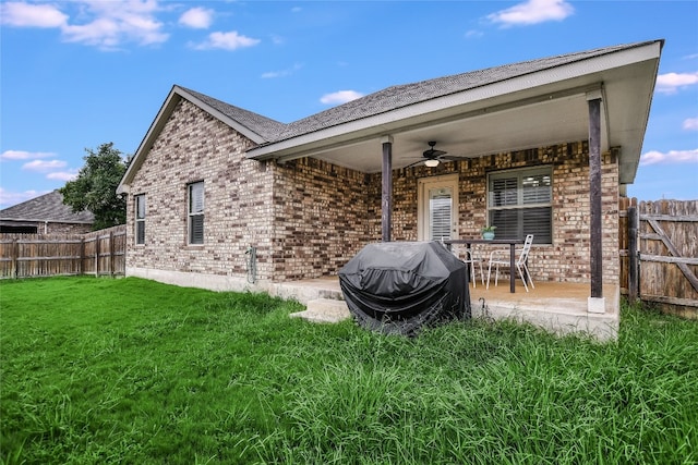 back of property with a patio area, a lawn, and ceiling fan