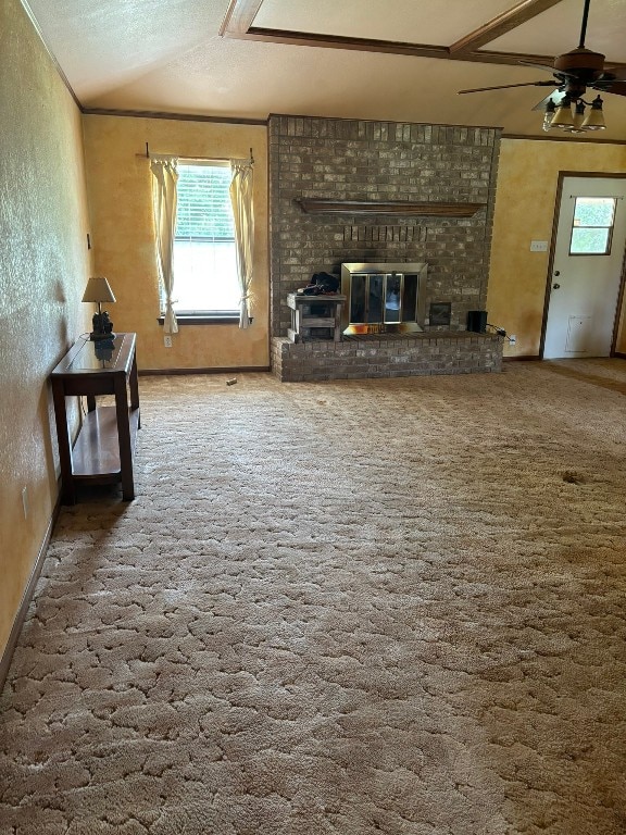 unfurnished living room featuring a fireplace, a textured ceiling, lofted ceiling, carpet flooring, and ceiling fan