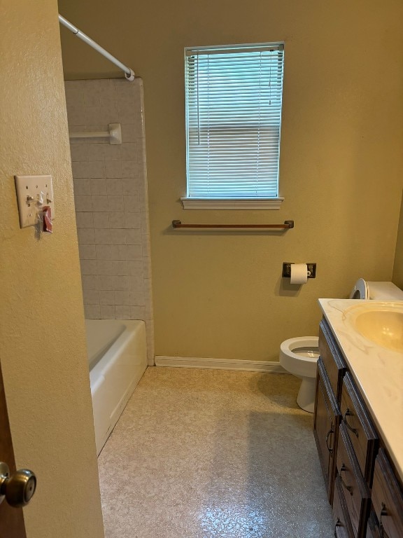 full bathroom featuring vanity, tiled shower / bath combo, and toilet