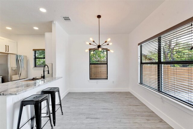 314 Saxon Ln, Austin, TX 78741 - unfurnished dining area with a chandelier, light wood finished floors, and recessed lighting