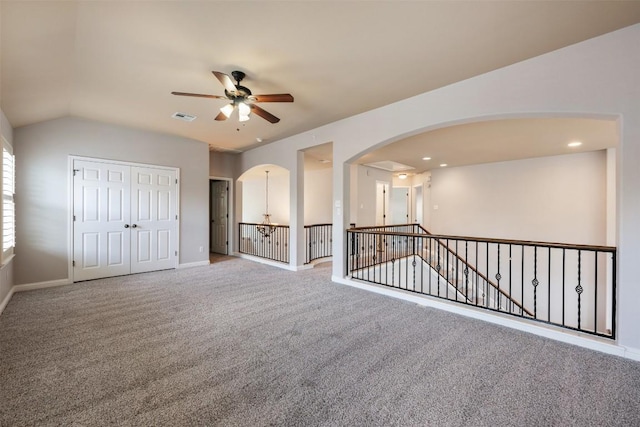 spare room featuring lofted ceiling, ceiling fan, and carpet