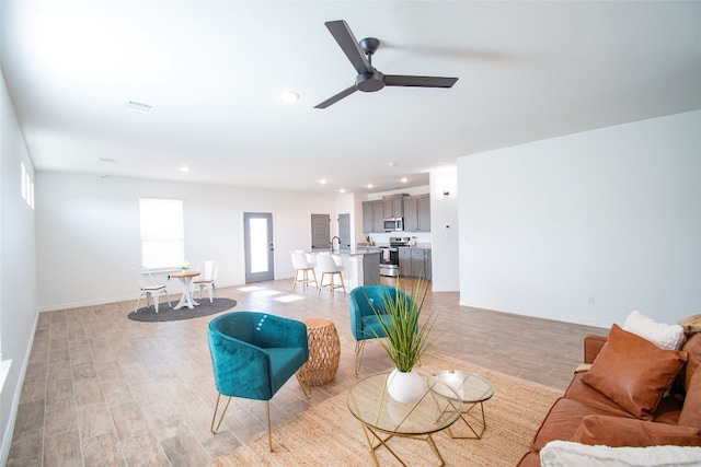 living room featuring ceiling fan and light hardwood / wood-style flooring