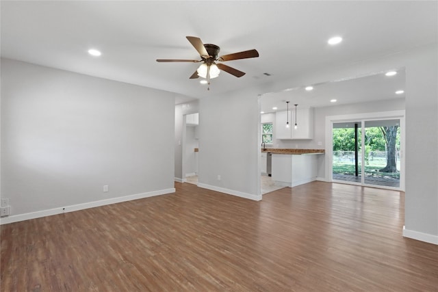 unfurnished living room with hardwood / wood-style floors and ceiling fan