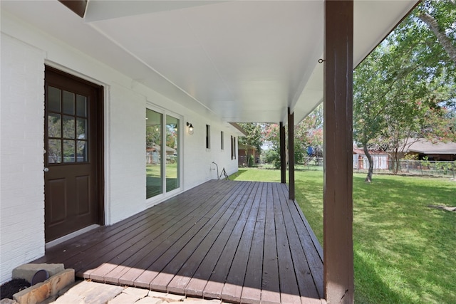 wooden terrace featuring a yard