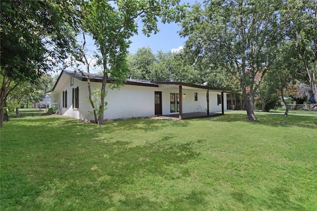 rear view of house featuring a lawn