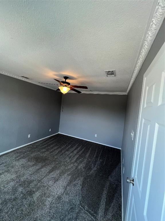 carpeted empty room featuring a textured ceiling and ceiling fan