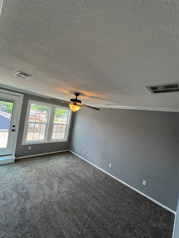 unfurnished room featuring a textured ceiling, ceiling fan, and carpet flooring