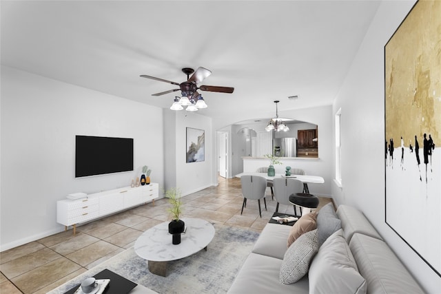 living room featuring ceiling fan with notable chandelier and light tile patterned flooring