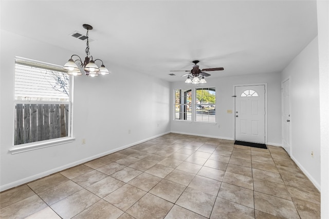 foyer with ceiling fan with notable chandelier and light tile patterned flooring