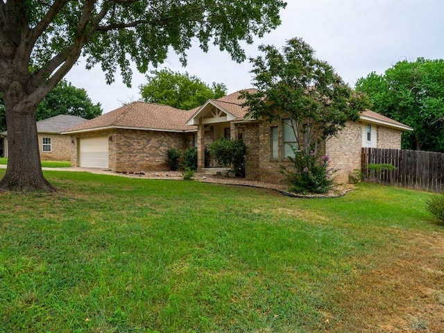 single story home with brick siding, an attached garage, fence, and a front yard