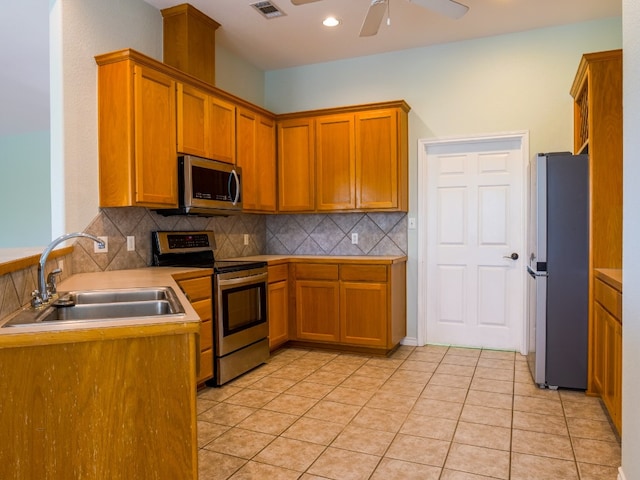 kitchen with sink, ceiling fan, stainless steel appliances, and backsplash