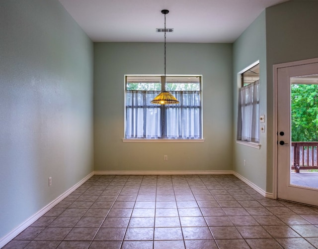 unfurnished dining area featuring tile patterned flooring