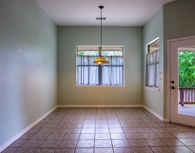 unfurnished dining area with tile patterned floors, baseboards, and visible vents
