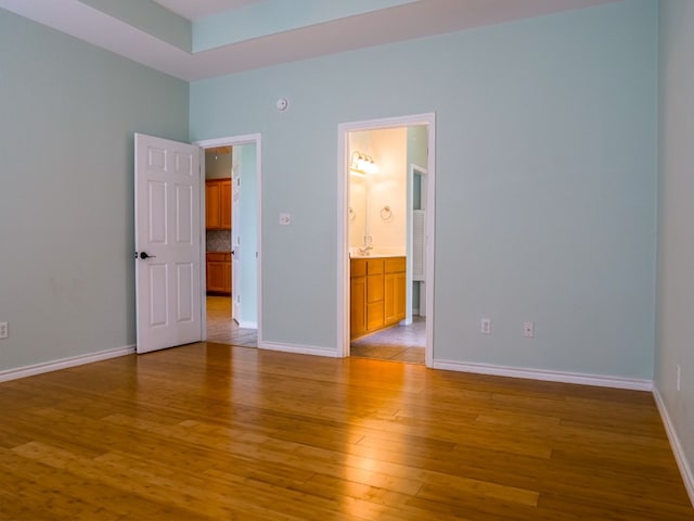 unfurnished bedroom with connected bathroom and tile patterned floors