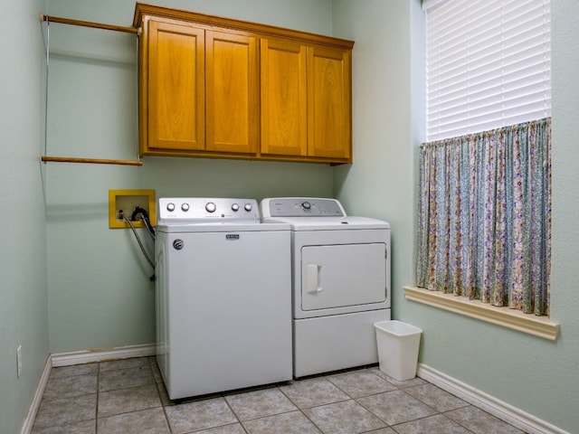 washroom with cabinets, washer and clothes dryer, and light tile patterned floors