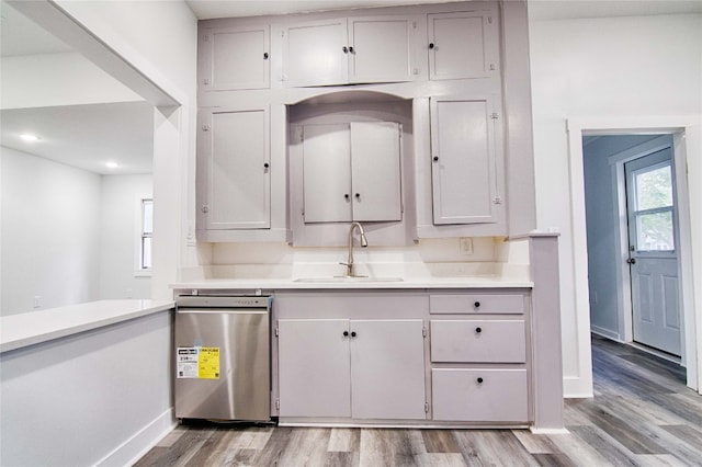 kitchen featuring sink, dishwasher, gray cabinets, and light hardwood / wood-style floors