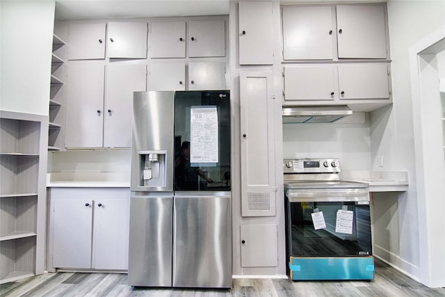 kitchen featuring appliances with stainless steel finishes, wall chimney range hood, white cabinetry, and light wood-type flooring