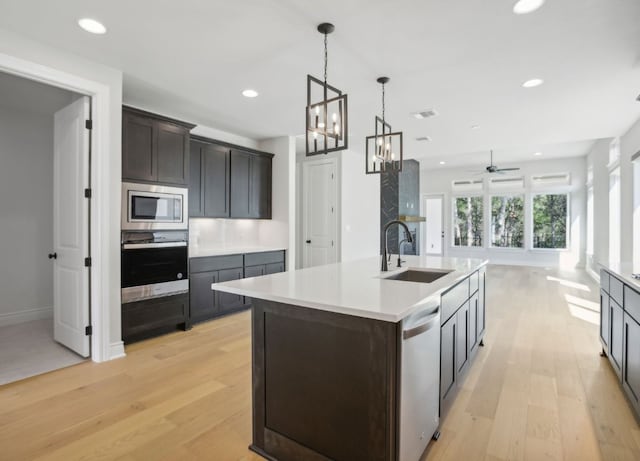 151 William Hersee Dr, Bastrop, TX 78602 - kitchen featuring appliances with stainless steel finishes, light wood-style flooring, a chandelier, a ceiling fan, and recessed lighting