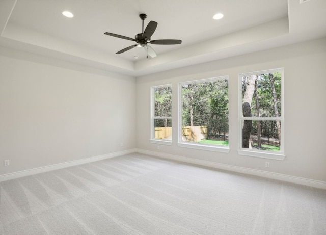 151 William Hersee Dr, Bastrop, TX 78602 - spare room featuring a tray ceiling, light carpet, plenty of natural light, recessed lighting, and a ceiling fan