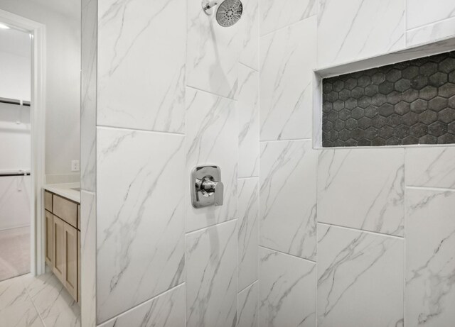 151 William Hersee Dr, Bastrop, TX 78602 - bathroom with tiled shower, vanity, a spacious closet, and marble finish floors