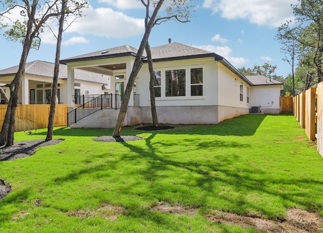 back of property with central air condition unit and a lawn