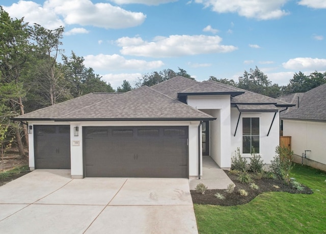 151 William Hersee Dr, Bastrop, TX 78602 - view of front of home with a shingled roof, driveway, an attached garage, stucco siding, and a front lawn