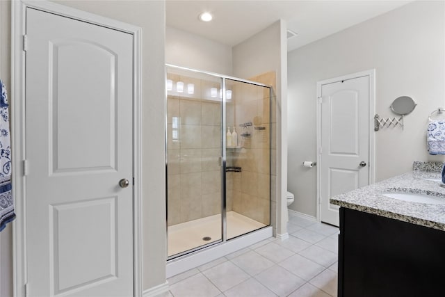 bathroom with toilet, tile patterned flooring, vanity, and walk in shower