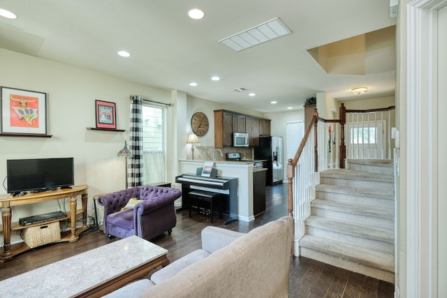 living room featuring sink and dark hardwood / wood-style flooring