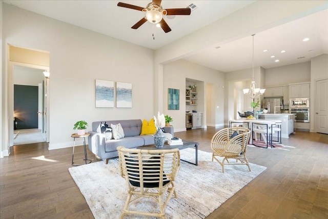 living room with hardwood / wood-style floors and ceiling fan with notable chandelier