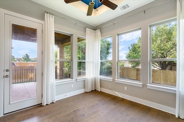 unfurnished sunroom with ceiling fan