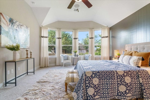 carpeted bedroom with multiple windows, wood walls, lofted ceiling, and ceiling fan