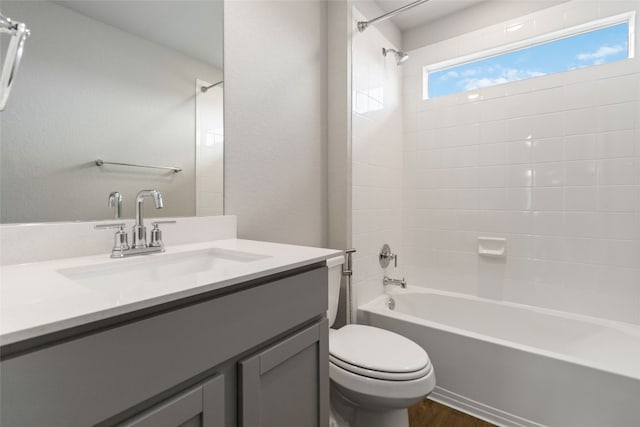 full bathroom with hardwood / wood-style flooring, tiled shower / bath combo, toilet, and vanity