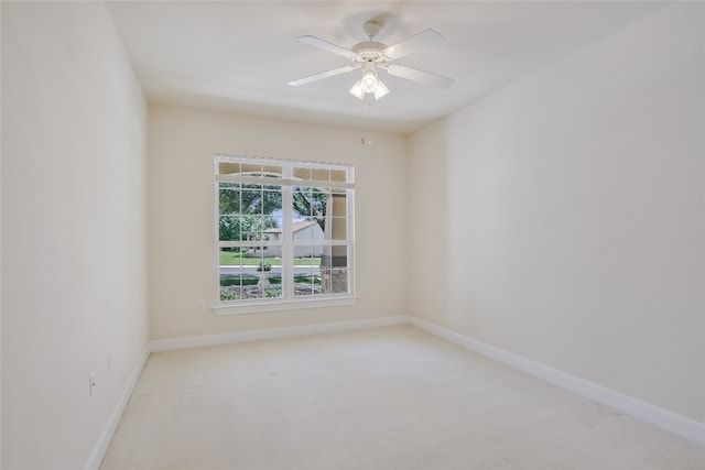 spare room with ceiling fan and light colored carpet